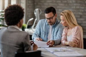 A couple reviewing paperwork with a car accident attorney