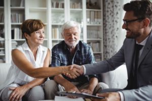 An attorney shaking hands with a couple